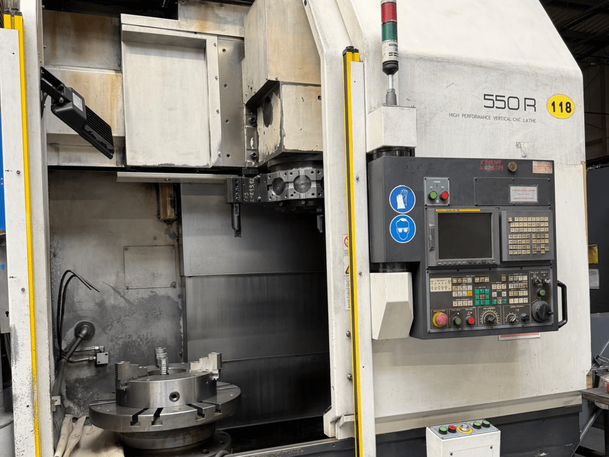 High Performance Vertical CNC Lathe 550 R, front view, showing control panel, rotating chuck, and operational components.