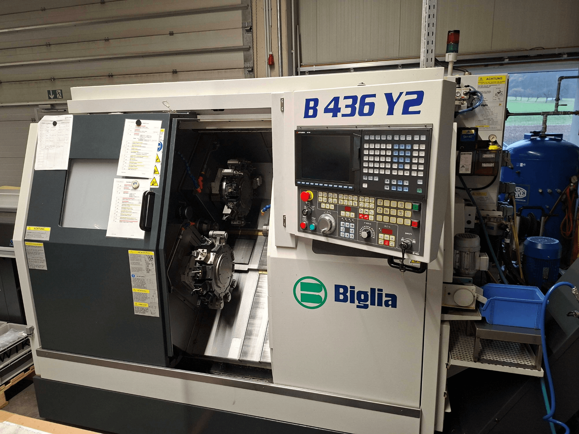 Biglia B 436 Y2 CNC lathe in side view, featuring dual spindles and control panel with buttons and display for operations.