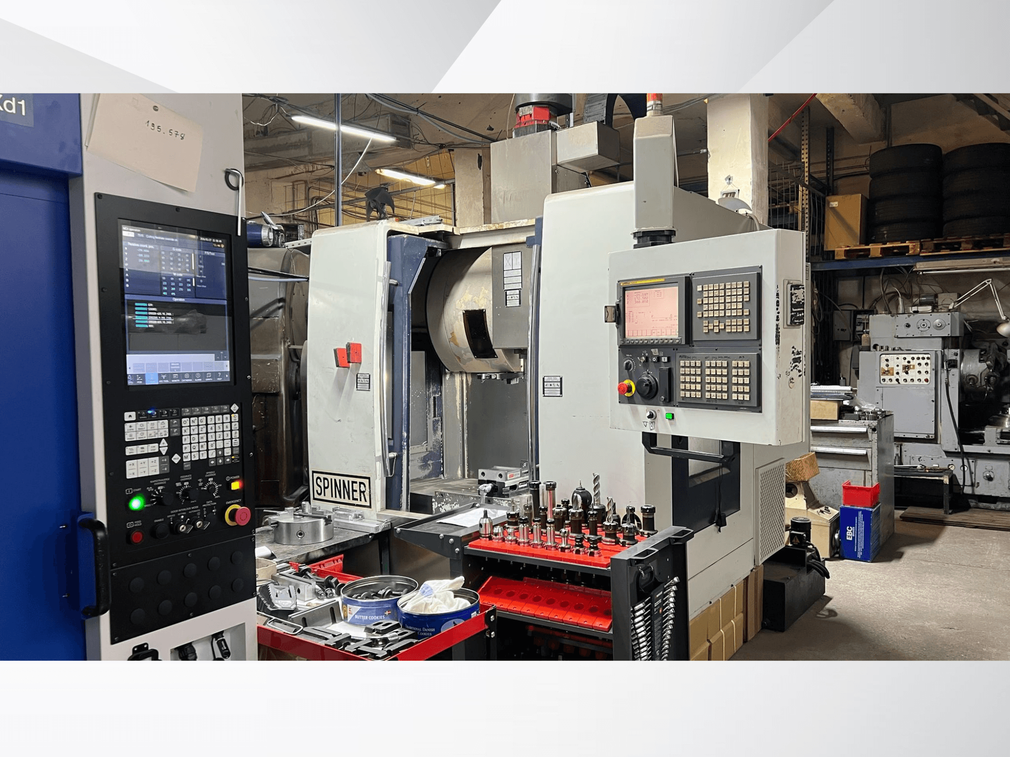 CNC machine with a control panel, tools, and workpieces visible, viewed from a front angle in a workshop environment.