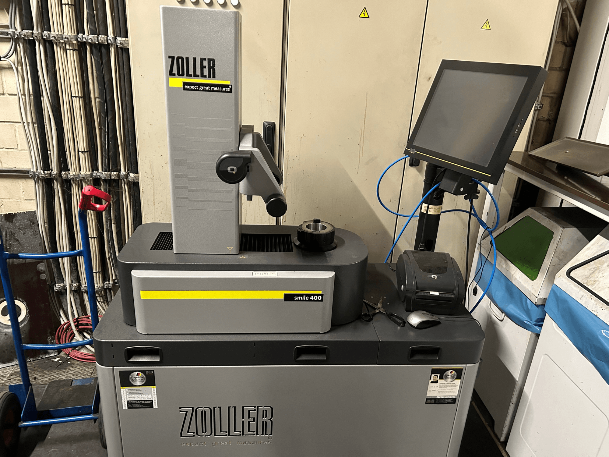 ZOLLER smile 400 measuring machine in gray, front view, with touchscreen, tool holder, and printer on a work surface.