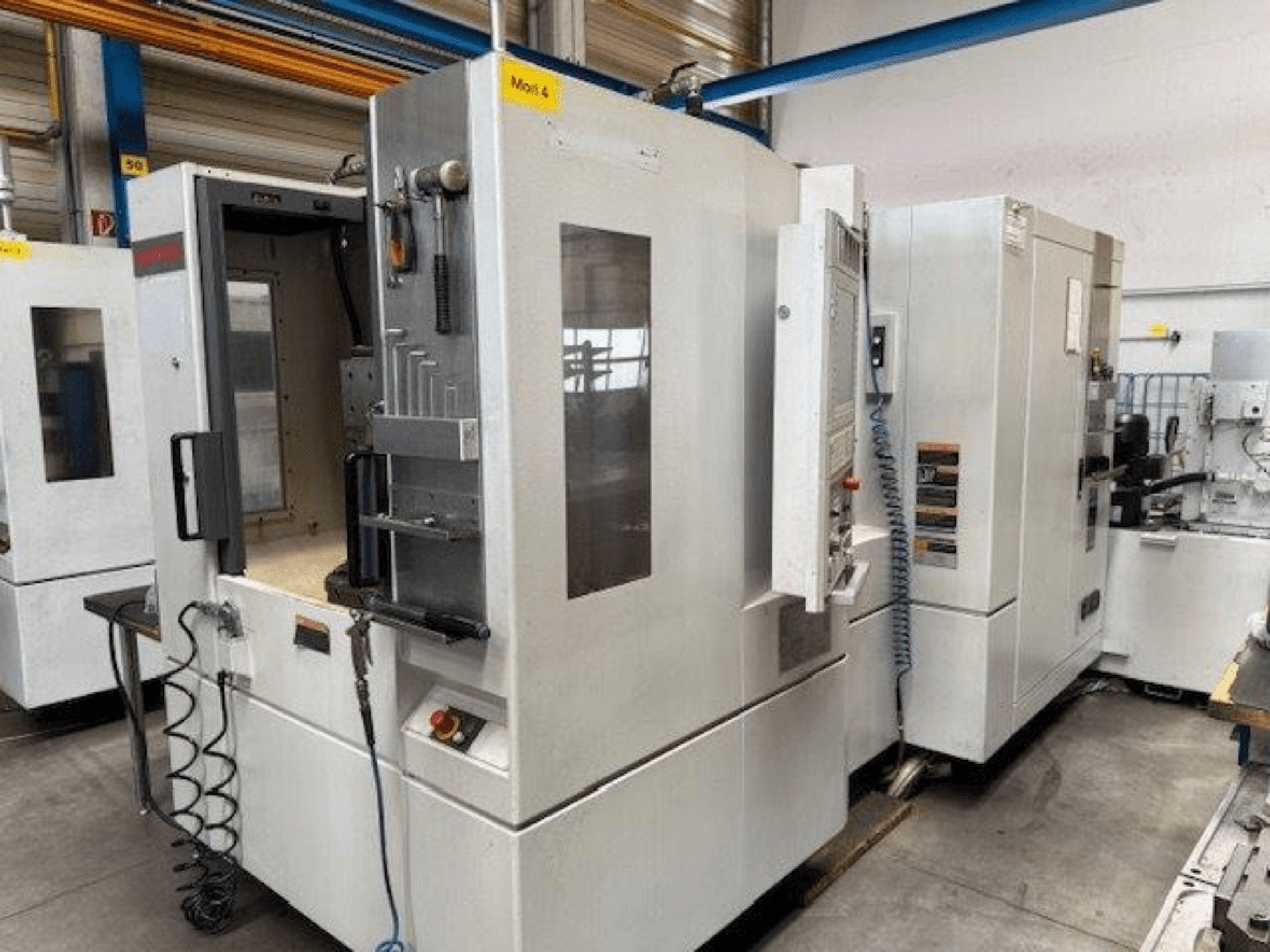 MORI SEIKI NH4000 DCG horizontal machining centre shown from the front, featuring an open door and control panel details.